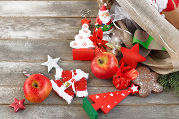 Christmas gifts falling  from  the decorated linen bag, holiday presents on the wooden grey table, holiday concept