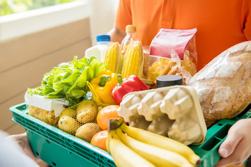 Grocery store delivery man delivering food to a customer at home