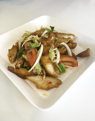 Spicy Chicken Salad in dish on white table.