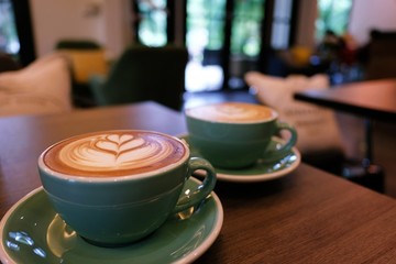 Cup of hot latte art coffee on wooden table.