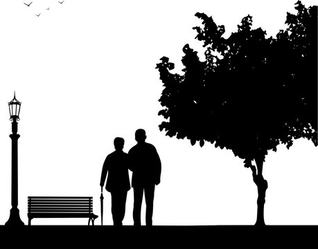 Lovely retired elderly couple walking with umbrella in park in autumn or fall, one in the series of similar images silhouette