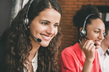 Smiling beautiful young woman telemarketing customer service agent working in call center in and...