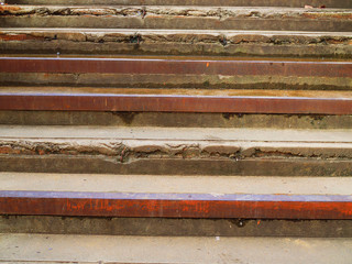 Aged weathered concrete ladder steps to upstairs with rusty steel border under warm sunlight, selective focus, perspective abstract background