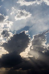 Powerful sun rays coming out through some clouds