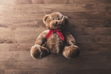 Cute fluffy smiling brown teddy bear toy on wood background