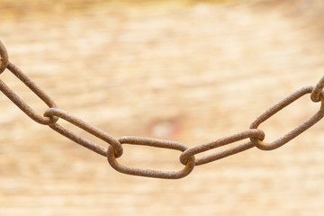 Obraz premium Old rusty metal chain on a wooden background. Selective focus
