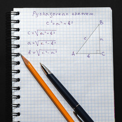 Page with formulas and the Pythagorean theorem with pen and pencil