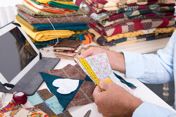 man fashion designer measuring a piece of fabric