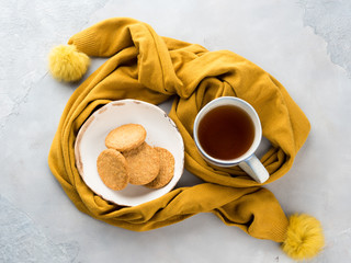 Obraz na płótnie Canvas Winter comfort food concept with woman's scarf, mug of tea and cookies. Moment of relax