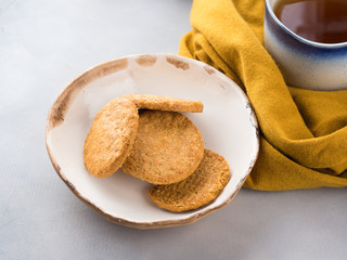 Winter comfort food concept with woman's scarf, mug of tea and cookies. Moment of relax