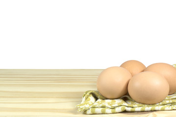 Eggs with fabric on the wooden table and white background.