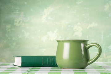 Green book and mug on the table