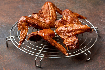 Smoked chicken wings on barbecue grill. Brown concrete background. Top view.