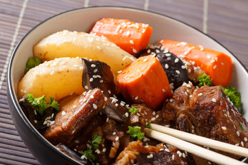 Korean cuisine: ribs stewed with mushrooms, pears and carrots close-up. horizontal