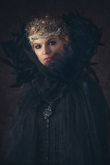 Queen of darkness in black fantasy costume on dark gothic background. High fashion beauty model...