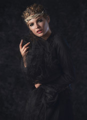 Queen of darkness in black fantasy costume on dark gothic background. High fashion beauty model...