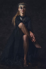 Queen of darkness in black fantasy costume on dark gothic background. High fashion beauty model...