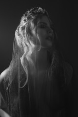 Queen of darkness in black fantasy costume on dark gothic background. High fashion beauty model...