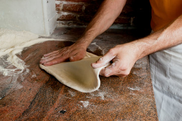 Preparing classical Pizza. Hands stretching the dough.