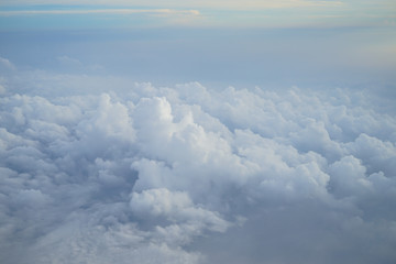 Fototapeta na wymiar Shades of light blue color sky and amazing white floating cloud view from airplane window