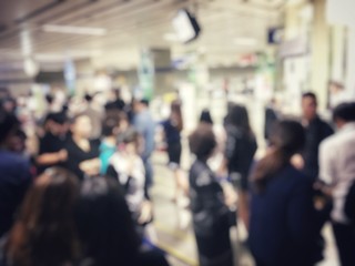 blurred image of asian people on the queue line on rush hour waiting for train subway station. Stay...