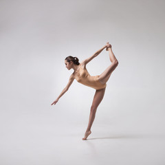 Obraz na płótnie Canvas young beautiful ballet dancer in beige swimsuit