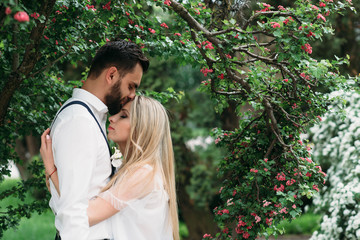 Young, beautiful bride and groom walking along in the park