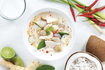 Coconut milk soup with chicken and Thai ingredients on the table, top view, Thai food that is popular in Thailand.