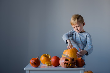 Young boy carving a  pumpkin  for halloween