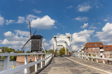 White bridge and historic windmill at a canal in Leiden