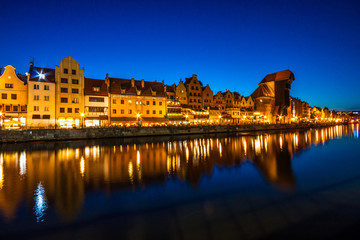 Gdansk old town and famous crane, Polish Zuraw. View from Motlawa river, Poland at romantic sunset, night.