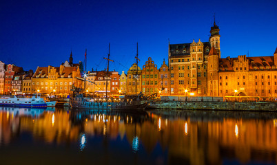Gdansk old town and famous crane, Polish Zuraw. View from Motlawa river, Poland at romantic sunset, night.