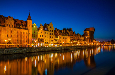 Gdansk old town and famous crane, Polish Zuraw. View from Motlawa river, Poland at romantic sunset, night.