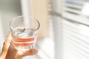 Woman holding a glass of water, close-up