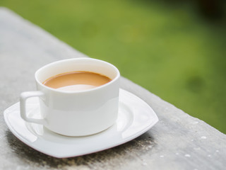 Soft focus coffee cup in garden.