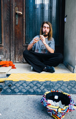 A young man performing with flute instrument on the street, Young man performer