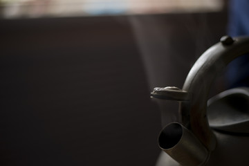 steam comes out of the kettle close up. the water evaporates. cozy kitchen.