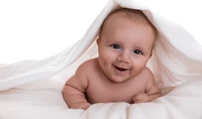 Baby boy peeping out from under sheet