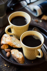 Two cups of black coffee with Italian almond cantuccini biscuits