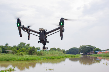 Professional camera drone flying on river and sky :  Drone black cover