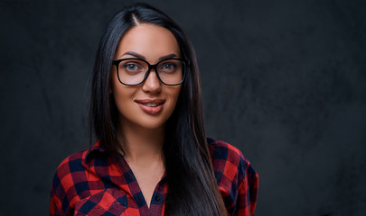 A woman dressed in a red shirt over grey background.