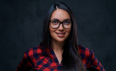 A woman dressed in a red shirt over grey background.