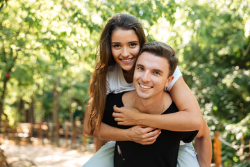 Fototapeta premium Young attractive couple enjoying piggyback ride