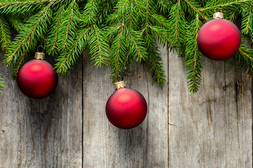 Christmas ornaments on fir branches, holiday decoration on wooden background, overhead
