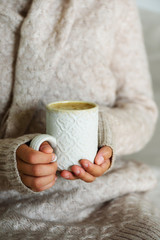 Obraz na płótnie Canvas Famale hands holding a cozy ceramic handmade mug with coffe. Winter and Christmas home time concept. Lifestyle. Copy space