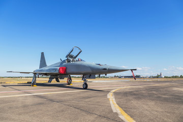 Fototapeta na wymiar fighter jet military aircrafts parked on runway in the base airforce on blue sky background