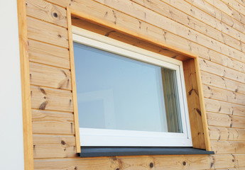 Plastic PVC Window in New Modern Passive Wooden House Facade Wall. PVC Windows are the Number One in House Energy Efficiency.