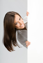 Businesswoman showing signboard, over grey