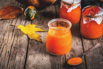 Autumn recipes, dishes from a pumpkin. Sweet spicy pumpkin jam in a serving jar, with a spoon, on...