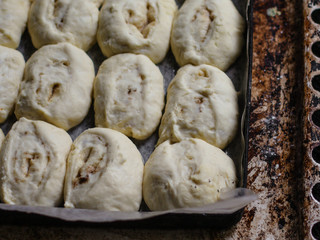 baking rolls with cinnamon - raw dough on a baking tray